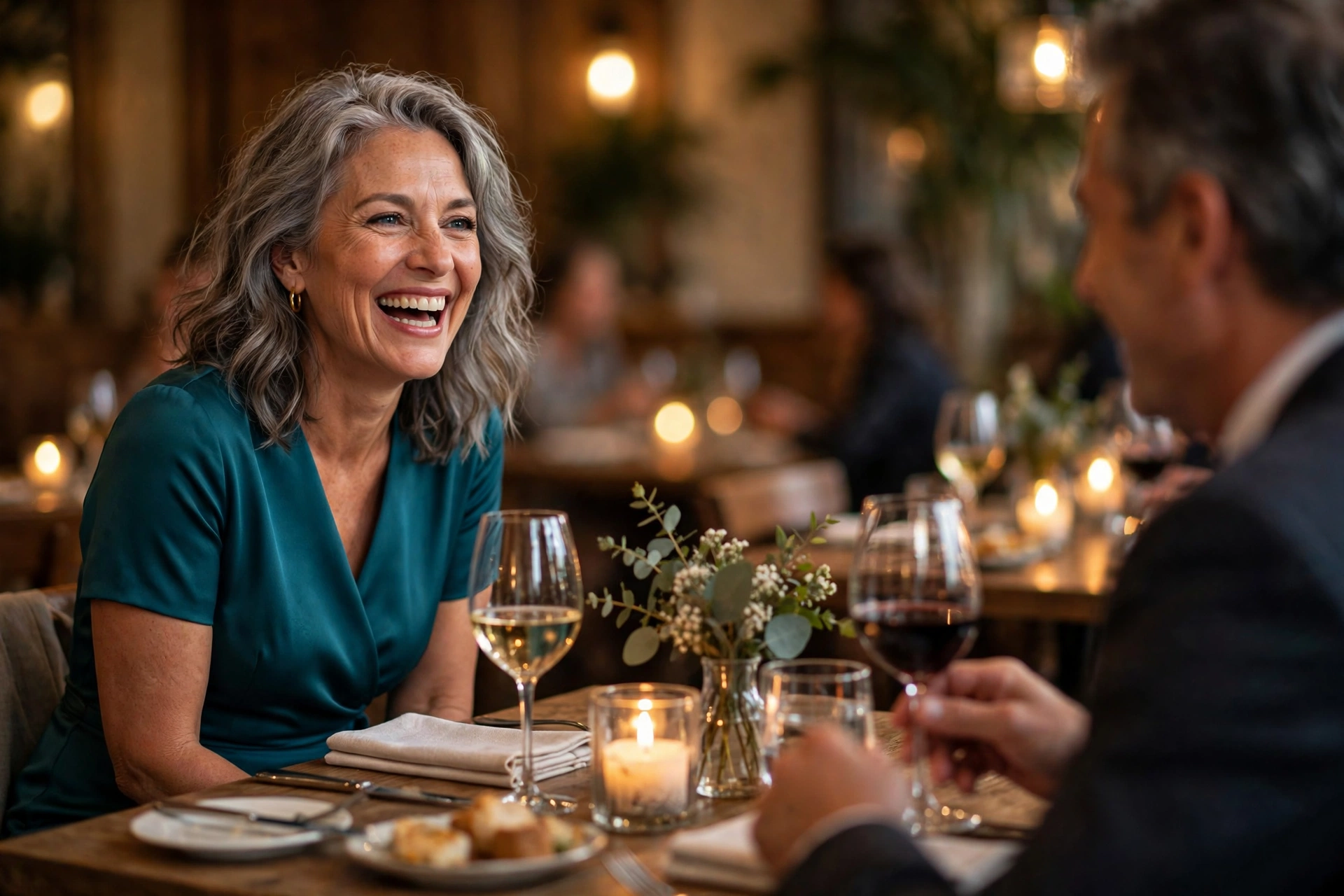 Happy confident woman over 50 in a teal midi dress laughing on a date