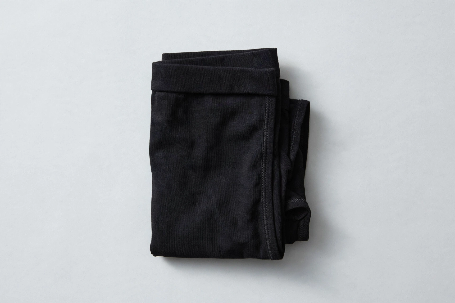 Folded black women's boyshort underwear on a light grey background