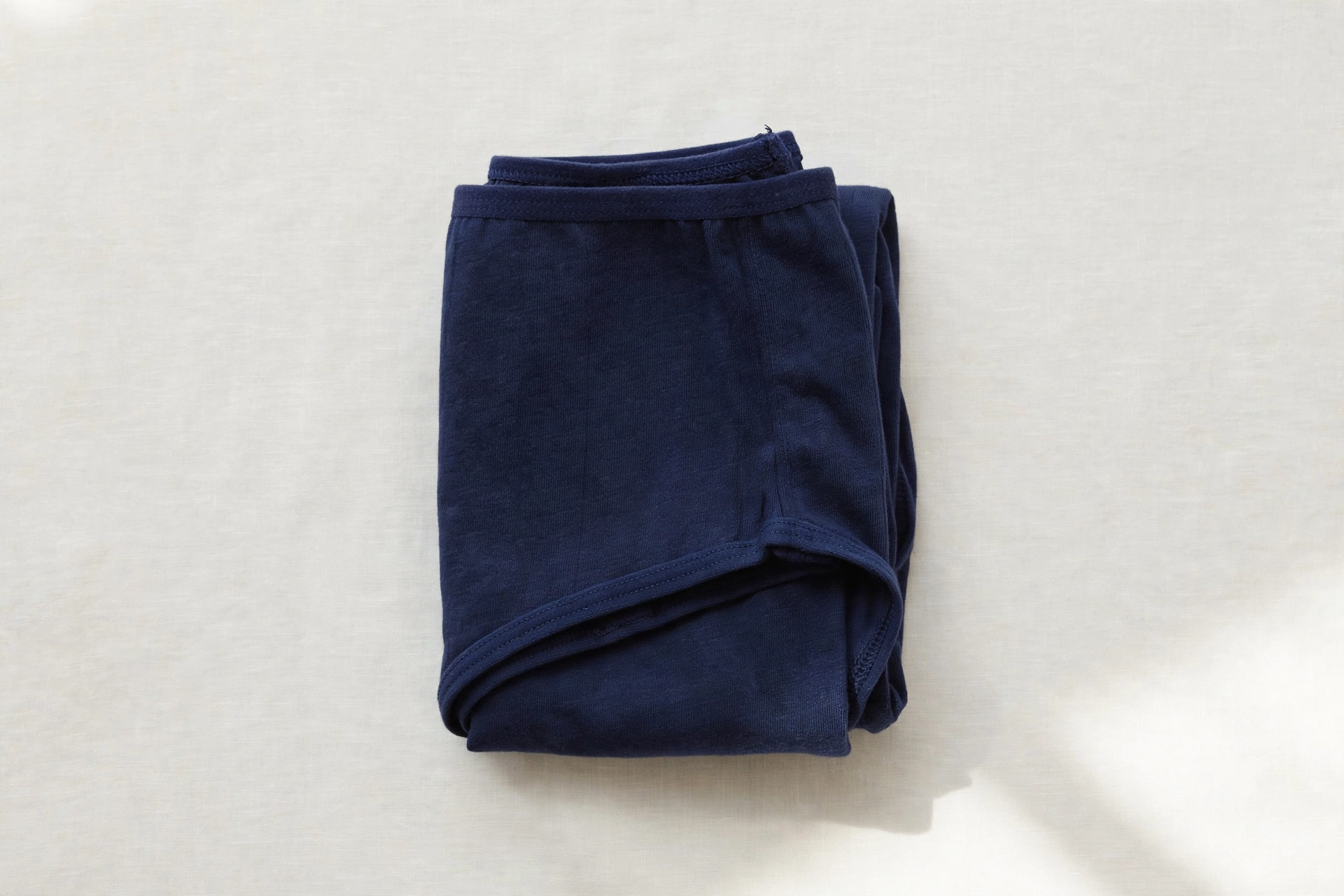 Folded navy blue full-coverage women's underwear briefs